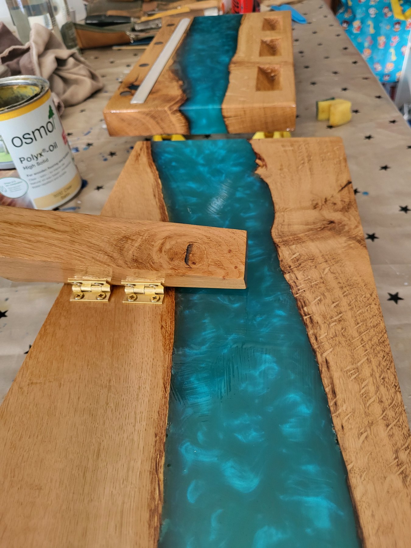 Workshop view of the folding oak and resin support strut of the Trio display, hinged in solid brass